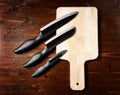 Sharp knives and chopping board on dark wooden table Royalty Free Stock Photo