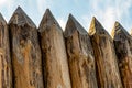 Sharp logs row of pointed trunks the base of a wooden fence stands against the sky Royalty Free Stock Photo