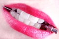 Sharp medical needle in the white teeth of a young woman Royalty Free Stock Photo