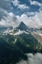 Sharp mountain peak landscape with cloudy sky, rocky ranges and peaks with glaciers and snow fields. Belalakaya, Dombay