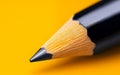 A sharp pencil tip is showcased against a vibrant yellow background, highlighting precision and creativity Royalty Free Stock Photo