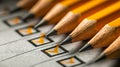Sharp pencils resting on a checklist with orange check marks, symbolizing completion and organization in a professional or Royalty Free Stock Photo
