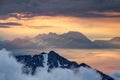 Sharp ridges of Slovenian Alps rise above orange sea of clouds Royalty Free Stock Photo