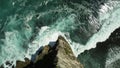 A sharp rock from aerial view, below is a powerful ocean. Intense blue ocean. Royalty Free Stock Photo