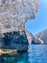 Sharp rock cliff in the beautiful and quiet shore Mediterranean waters in Malta Island Royalty Free Stock Photo