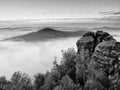 Sharp sandstone rock empire sticking out from heavy fog. Deep misty valley Royalty Free Stock Photo