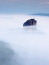 Sharp sandstone rock empire sticking out from heavy fog. Deep misty valley Royalty Free Stock Photo