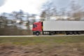 The sharp silhouette of the car in motion against the background of a blurred forest. Panoraming. Spring