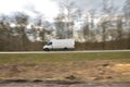 The sharp silhouette of the car in motion against the background of a blurred forest. Panoraming. Spring