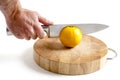 Sharp stainless steel knife cutting into orange