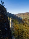 The sharp summit of Seneca Rocks, West Virginia, lit by sunlight, mountains in fall collors and blue sky Royalty Free Stock Photo