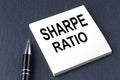 SHARPE RATIO text on the sticker with pen on the black background