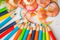 Sharpened color pencil and pencil shavings, Hands of a child on a white background