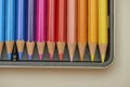 Sharpened colored pencil tips aligned in metal case showing warm color spectrum Royalty Free Stock Photo