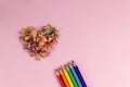 Sharpened colored pencils and heart-shaped pencil shavings on pastel pink color. Rainbow or LGBT pencils. Decoration for St. Royalty Free Stock Photo