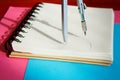 Sharpened colored pencils lie together with a blank notepad on a blue background Royalty Free Stock Photo