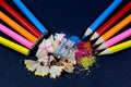 Sharpened Colorful Pencils Against Blunt Pencils with Metallic Pencil Sharpener and Colorful Pencil Shavings on Black Royalty Free Stock Photo