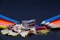 Sharpened Colorful Pencils Against Blunt Pencils with Metallic Pencil Sharpener and Colorful Pencil Shavings on Black Royalty Free Stock Photo