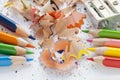 Sharpened colorful pencils, wood shavings and sharpener, closeup Royalty Free Stock Photo