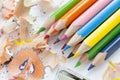 Sharpened colorful pencils, wood shavings and sharpener, closeup Royalty Free Stock Photo