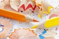 Sharpened colorful yellow and orange pencils and wood shavings, drawing concept Royalty Free Stock Photo