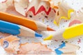 Sharpened orange, yellow, blue pencils and wood shavings, drawing concept Royalty Free Stock Photo