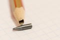 Sharpened pencil with a broken tip over a blank sheet of paper Royalty Free Stock Photo