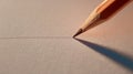 A sharpened pencil touches the textured paper while drawing a thin line in soft light Royalty Free Stock Photo