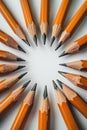 Sharpened pencils arranged in a circular pattern on a white surface, top view Royalty Free Stock Photo