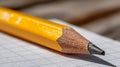 A sharpened yellow pencil resting on a lined sheet of paper. Royalty Free Stock Photo