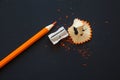 Sharpener and orange pencil on black Royalty Free Stock Photo