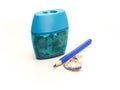 Sharpener and sharpened blue pencil with a shaving Royalty Free Stock Photo