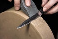 Sharpening a Damascus steel knife on the water stone of a grinding machine Royalty Free Stock Photo