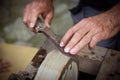 Sharpening knife on old grindstone wheel Royalty Free Stock Photo