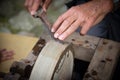 Sharpening knife on old grindstone wheel Royalty Free Stock Photo