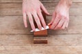 Sharpening the knife with a whetstone on a wooden background. Top view