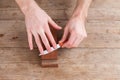 Sharpening the knife with a whetstone on a wooden background. Top view.