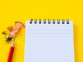 Sharpening a red pencil sharpener and the note book On yellow background. Royalty Free Stock Photo