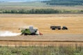 Combined harvester and tractor-trailer rides on the field during harvesting