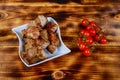 Shashlyk pork on skewers on a dark wooden board with tomatoes, spinach and sauces Royalty Free Stock Photo