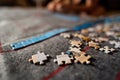 Shattered colorful jigsaw puzzle pieces kept in front against out of focus hand of a girl playing with them by completing an image Royalty Free Stock Photo