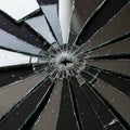 A shattered mirror with radiating cracks forms a circular pattern. Royalty Free Stock Photo