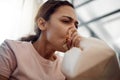 The shattered remains of love betrayed. a young woman experiencing a panic attack while sitting on the sofa at home. Royalty Free Stock Photo