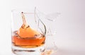 A shattering glass of brandy or brandy. Shards of glass and splashes of drink Royalty Free Stock Photo