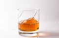 A shattering glass of brandy or brandy. Shards of glass and splashes of drink Royalty Free Stock Photo