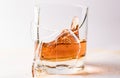 A shattering glass of brandy or brandy. Shards of glass and splashes of drink Royalty Free Stock Photo