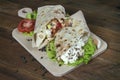 Shaurma chicken roll in a pita with fresh vegetables and cream s