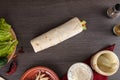 Shaurma chicken roll in a pita with fresh vegetables and cream sauce composition on wooden background Royalty Free Stock Photo