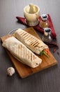 Shaurma chicken roll in a pita with fresh vegetables and cream sauce composition on wooden background Royalty Free Stock Photo