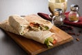 Shaurma chicken roll in a pita with fresh vegetables and cream sauce composition on wooden background Royalty Free Stock Photo